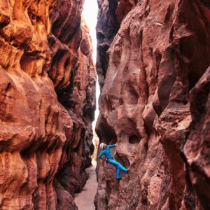 a man climbing up the side of a canyon