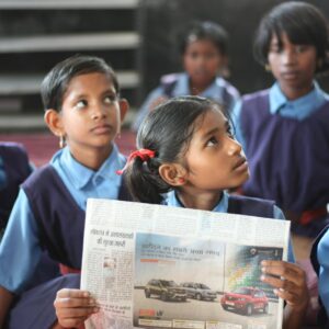 shallow focus photo of girl holding newspaper