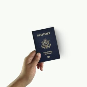 a hand holding a passport over a white background