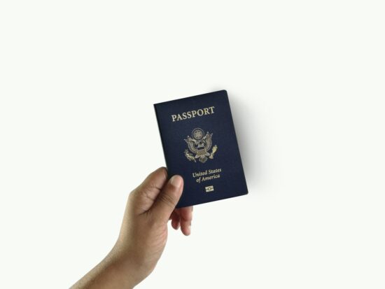 a hand holding a passport over a white background
